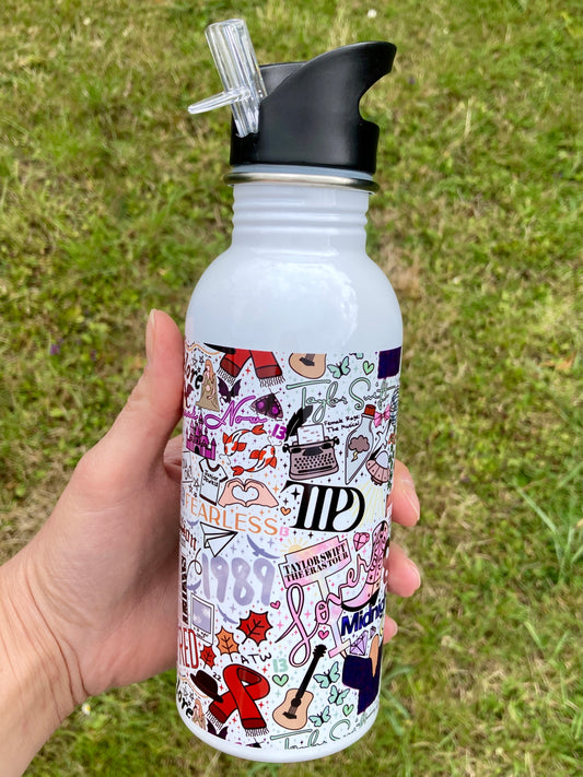 White water bottle with colorful designs held in a hand against a grassy background