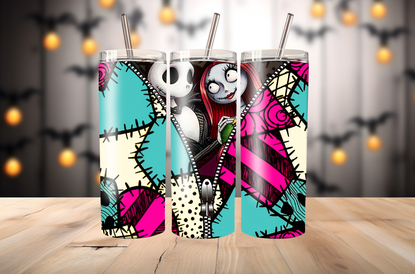 Three colorful tumblers with Halloween-themed designs on a wooden surface.